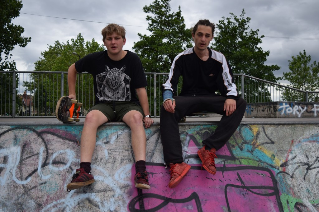 Chester and Fred sitting on a skatepark ramp
